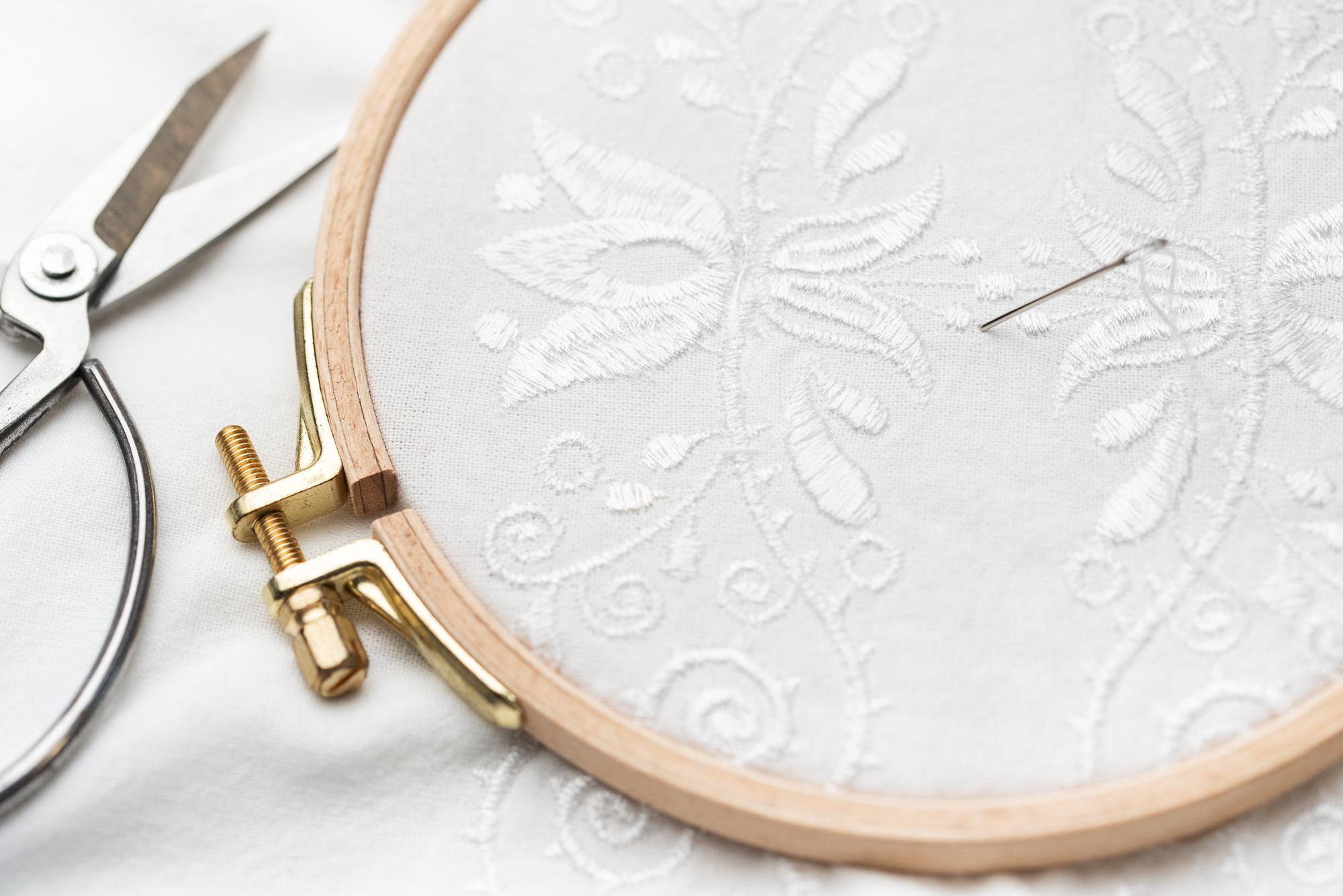 Needle and detailed floral embroidery on linen